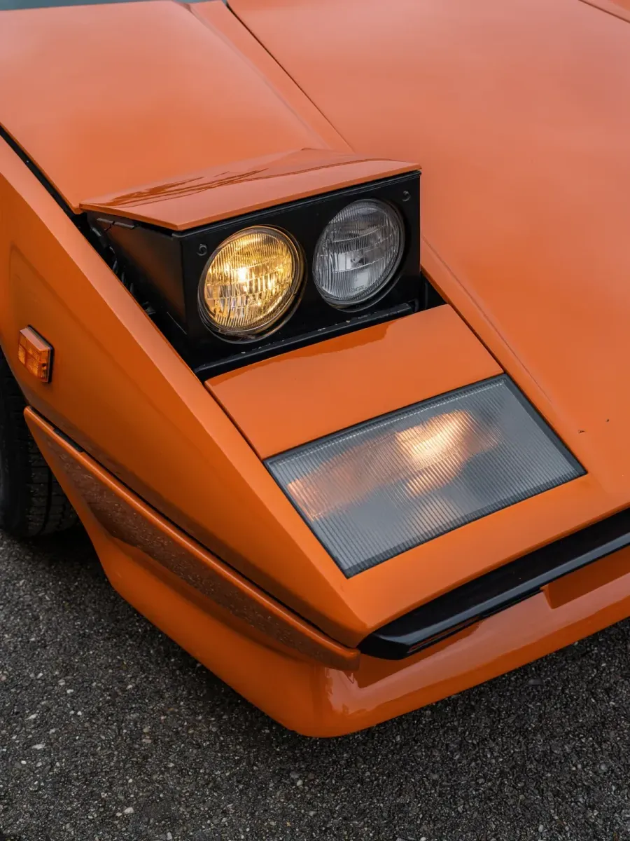 orange 1980s sports car with pop-up headlights, detail