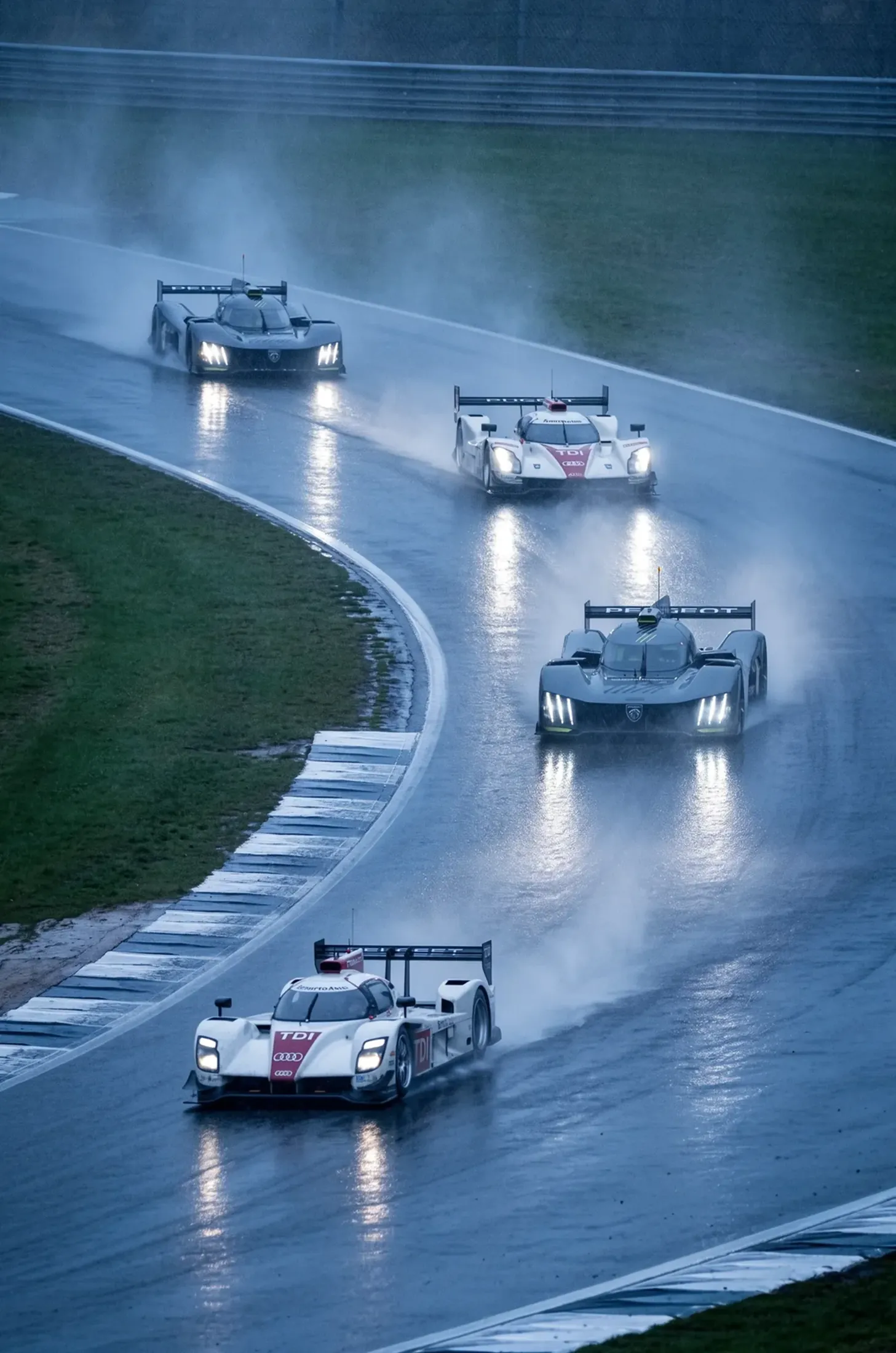 endurance race cars at night in the rain, long lens